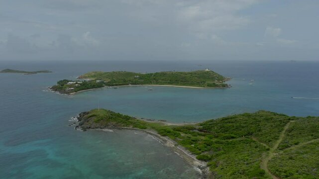 Aerial Scenic View Of Epstein Island On Wavy Sea, Drone Flying Backwards During Sunny Day - VI, 
Little Saint James, United States of America
