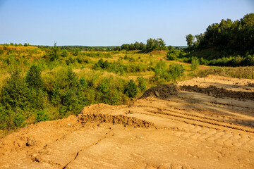 Naklejka premium Overburden dump on the overgrown part of a worked-out quarry
