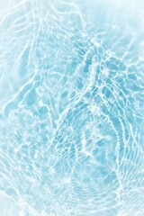 Bluewater waves on the surface ripples blurred. Defocus blurred transparent blue colored clear calm water surface texture with splash and bubbles. Water waves with shining pattern texture background.