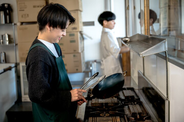 調理する男性と運ぶ男性