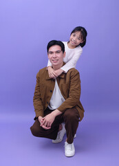 Young Asian father and daughter on purple background