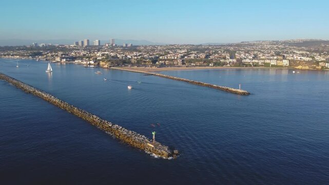 Newport Beach, Pan Past - Jetty Canal, Port Harbor Bay Entrance - to Balboa Peninsula Orange County, Southern California Coast, USA. Corona Del Mar. Mountain View, City Skyline on Hillside.