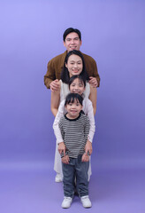 Young Asian family on purple background