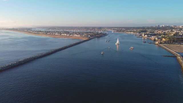 Newport Beach, Pan Past - Jetty Canal, Port Harbor Bay Entrance - to Balboa Peninsula Orange County, Southern California Coast, USA. Corona Del Mar. Sunset Mountain View, City Skyline on Hillside.