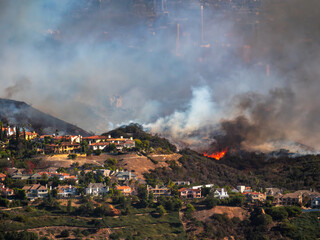Wildfire near homes with Los Angeles City background