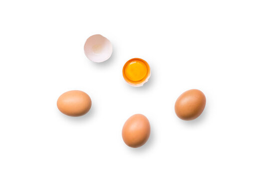 Closeup of brown organic free-range chicken eggs with broken egg isolated on a transparent background with shadow from above, top view