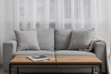 Grey sofa with wooden table in interior of modern living room
