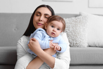 Young mother hugging her baby at home. International Hug Day