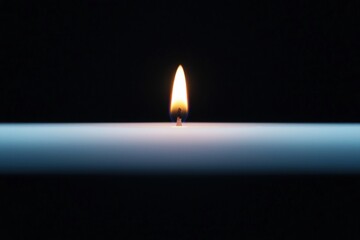 Burnout recovery focus concept. Candle flame glowing against a dark background.
