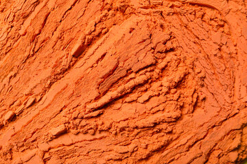 Orange powder pigment as background, closeup