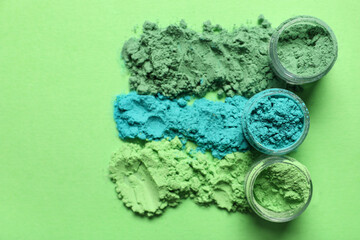 Jars of powder pigments on green background