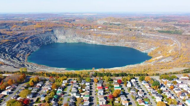 Aerial view of abandoned Thetford open pit mine with lake and picturesque neighborhood next to it. Black Lake, Qu&eacute;bec, Canada