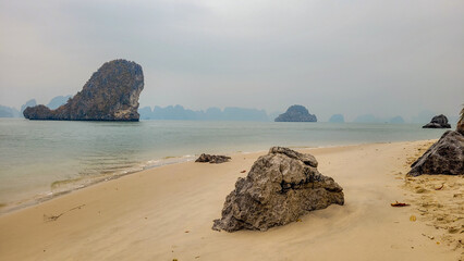 A beach with rocks and sand in Hạ Long Bay, Vietnam.