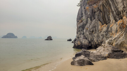 A beach with rocks and sand in Hạ Long Bay, Vietnam.