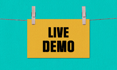 Live Demo Symbol. Concept words Live Demo on Yellow Rectangle Paper Hanging on a Wooden Clothespin Green Background. Business Live Demo Concept with Copy Space