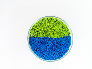Colorful masterbatch plastic granules in transparent glass cup, polymer carrying pigment poured in...
