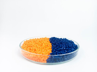 Colorful masterbatch plastic granules in transparent glass cup, polymer carrying pigment poured in...