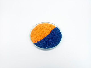 Masterbatch plastic, colorful polymer granules carrying pigments are poured into a glass cup with...
