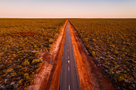 Man standing in the middle of the road in the outback, aerial view, Australia