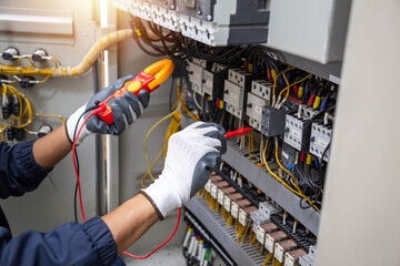 Checking the electrical system, an electrician is using an electric meter to check the electrical...
