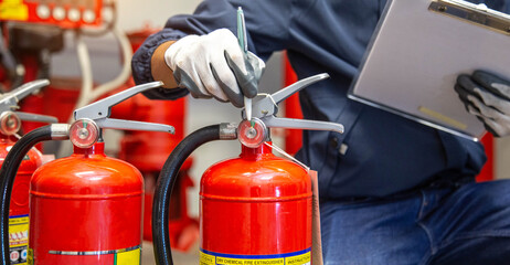 Engineer are checking and inspection a fire extinguishers tank in the fire control room for safety training and fire prevention.