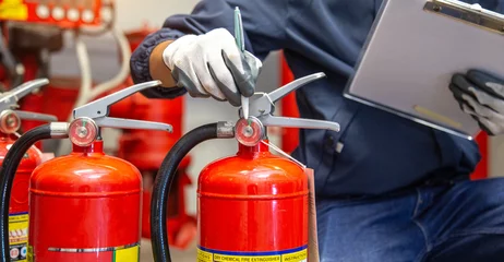 Fototapeten Feuer & Flamme Engineer are checking and inspection a fire extinguishers tank in the fire control room for safety training and fire prevention.  © A Stockphoto
