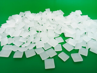 hot glue, dry glue beads, hot melt polymer, isolated on green background, for industrial plastics...