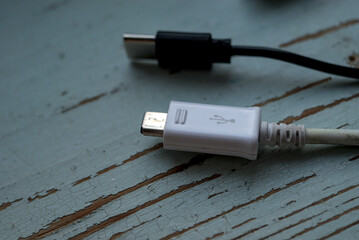 White and black usb cables on the wood