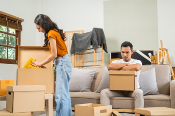 Young couple experiencing relationship issues,gathering belongings, packing items into box,engaging...