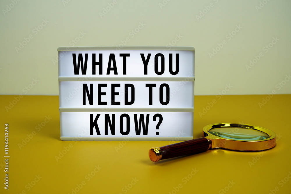 Poster what you need to know? text on led lightbox with magnifying glass on yellow background