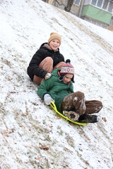 Children are walking, hiking,, sledding and playing in a snowy park. Winter fun and outdoor activities with kids