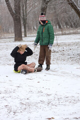 Children are walking, hiking,, sledding and playing in a snowy park. Winter fun and outdoor activities with kids