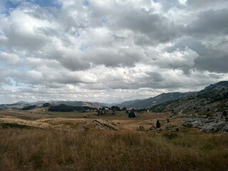 clouds over the mountains on dry field