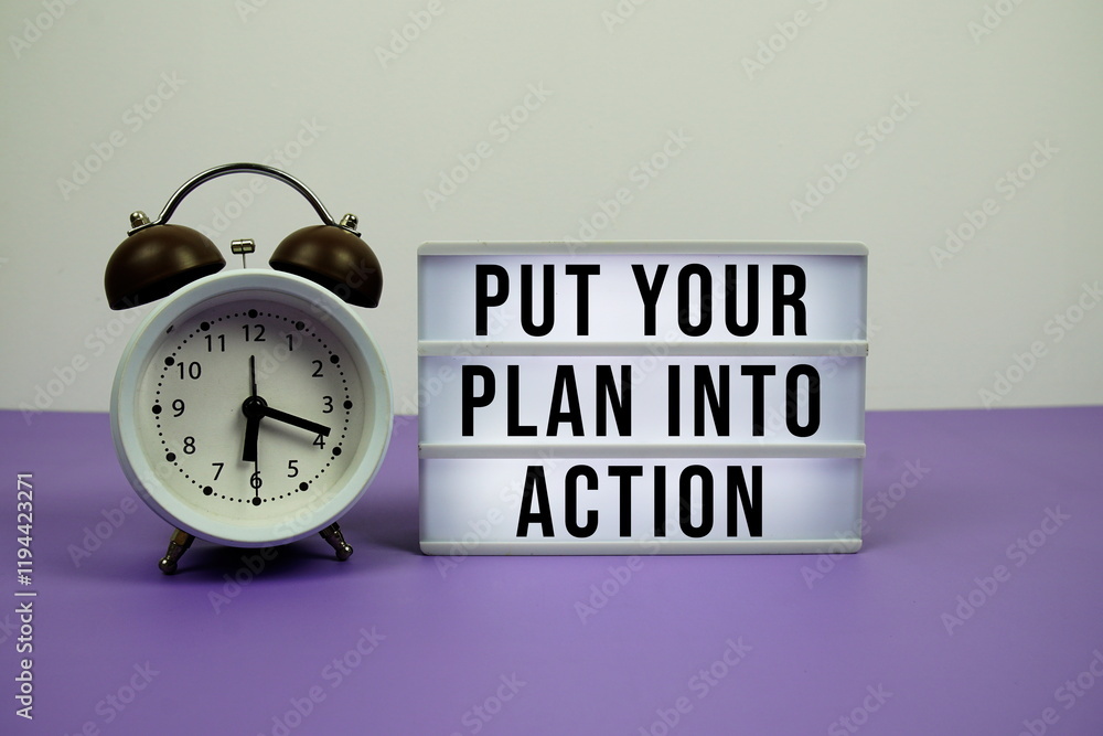 Poster put your plan into action text on light box with alarm clock on purple background