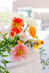 Close-up of poppy flowers and greenery wedding table centerpiece.