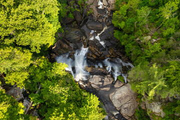 Beautiful landscape of high waterfall with falling down clear water from rocky boulders between green lush woods. Whitewater Falls in Nantahala National Forest, North Carolina, USA