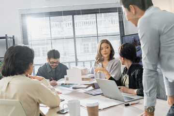 Collaborative business team discussing architectural project strategy in modern office meeting