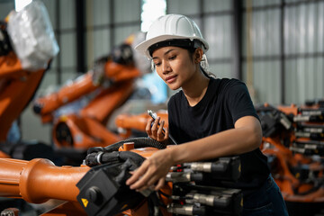Professional female engineer wearing a safety helmet and black shirt, inspecting and adjusting an...