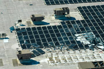 Top view of destroyed by hurricane Ian photovoltaic solar panels mounted on industrial building...