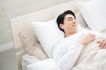 ベッドで寝る男性　安眠のイメージ