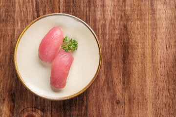 Tuna Nigiri Sushi Served with Parsley on a Light-Colored Plate