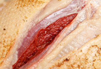 A close up of a chicken's leg with a red mark on it