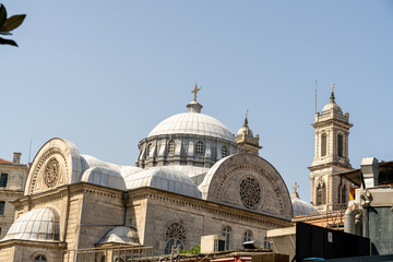 Fototapeta premium A large church with a dome on top and a cross on top of it. The sky is blue and clear