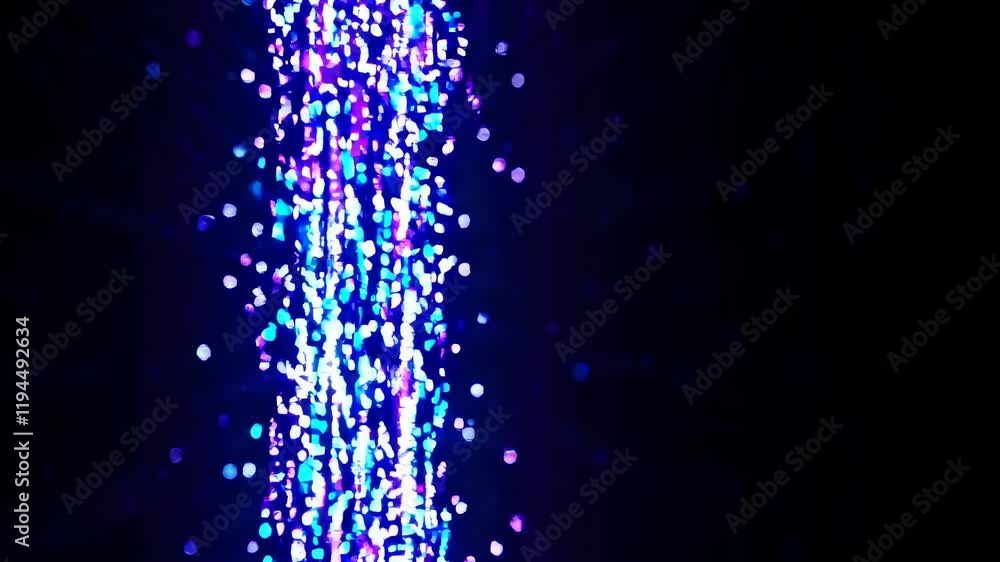 Poster colorful light display creates mesmerizing waterfall effect in a nighttime setting
