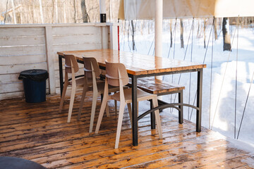 A beautifully crafted wooden table accompanied by a set of charming chairs is resting majestically on a sturdy wooden floor, creating a warm and inviting atmosphere in the room