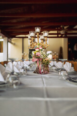 Elegant Wedding Table Decoration with Golden Candle Holders and Floral Arrangements on Terrace