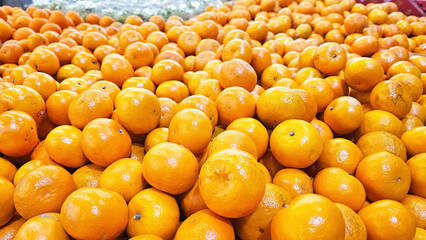 A vibrant display of fresh oranges stacked in a market, showcasing their bright color and natural appeal. Juicy oranges, their bright color suggesting sweetness and vitality.  