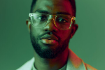 Portrait of a young man with glasses on a colorful background, showcasing confidence and style, perfect for modern lifestyle themes, emotions, and individuality
