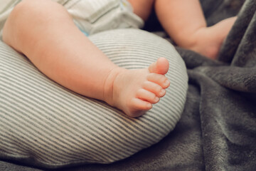 Tiny Baby Feet Resting on a Cushion