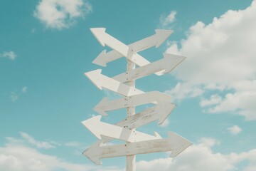 Multiple white wooden arrows pointing in different directions against a bright blue sky with fluffy clouds.
